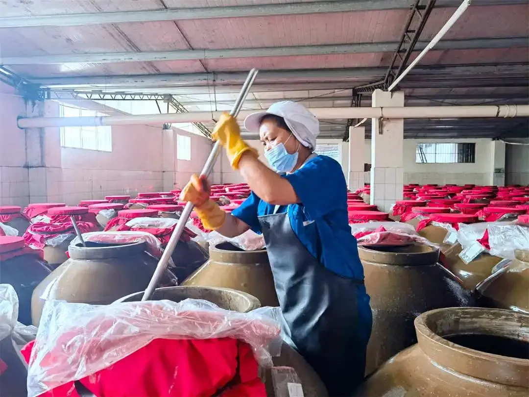 4-7 Рабочий на заводе Mingyang Food Co., Ltd. в уезде Мацзян перемешивает ферментированный кислый суп.